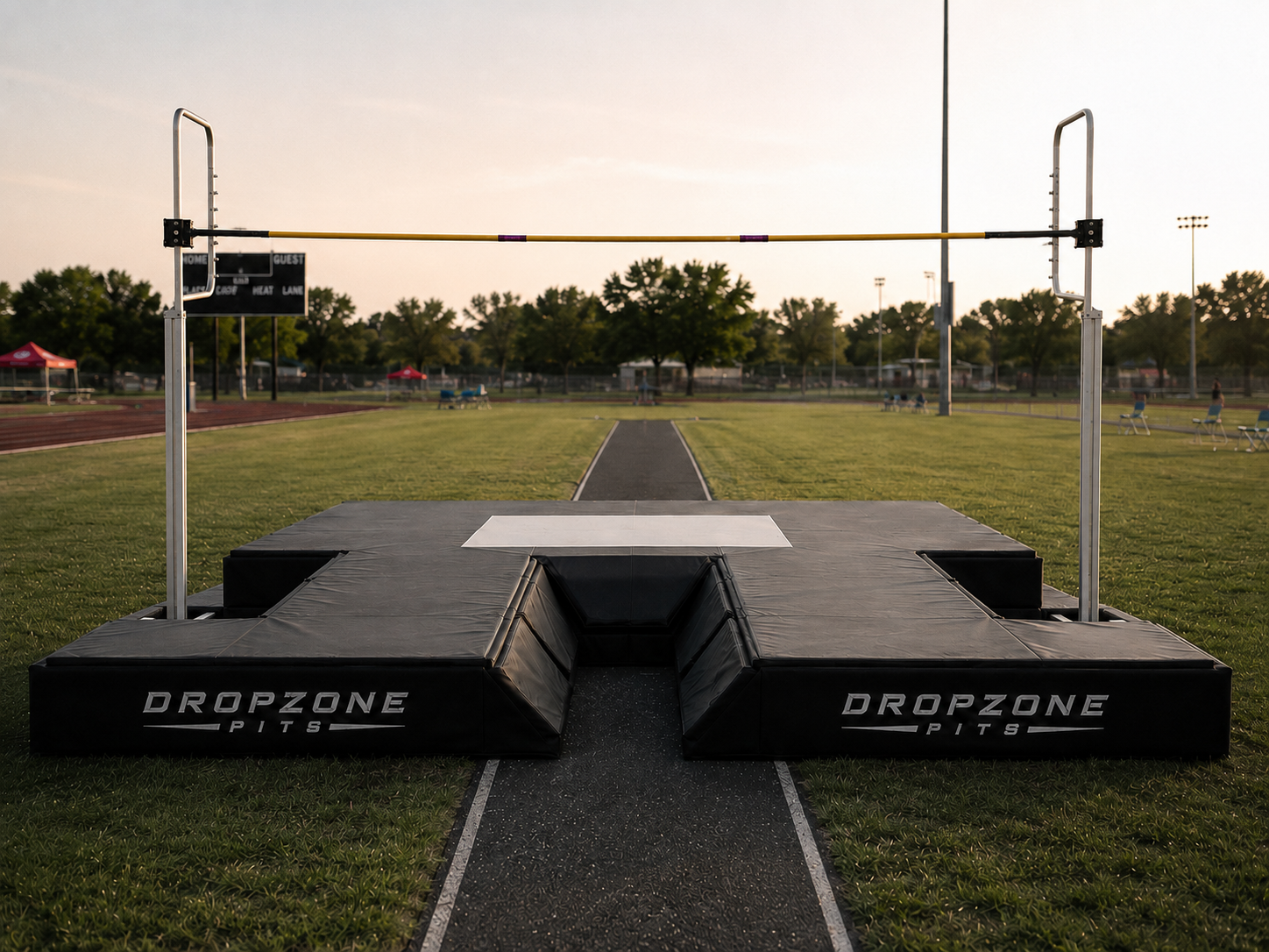 Dropzone Pits pole vault landing system set up on a track at sunset